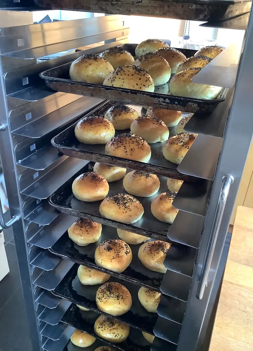ラックの天板ごとに整列した、焼き上がったばかりの自家製バンズ